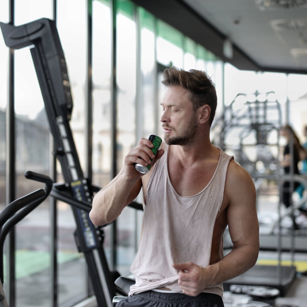 Man in a gym holding a smartphone with a blurred background